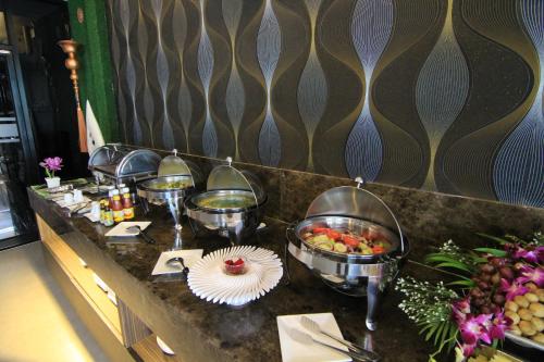 ein Buffet mit Schalen mit Speisen auf der Theke in der Unterkunft Inn Residence Serviced Suites - SHA Extra Plus in Jomtien Beach