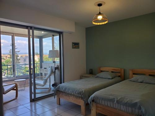 une chambre avec deux lits et un balcon dans l'établissement Port FREJUS 3 Pieces climatise 80m2 Proche de tout, à Fréjus