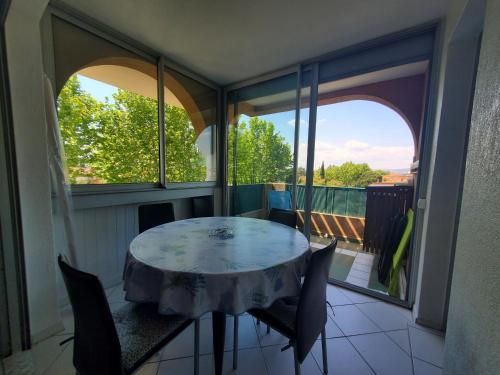 une pièce avec une table et des chaises sur un balcon dans l'établissement Port FREJUS 3 Pieces climatise 80m2 Proche de tout, à Fréjus