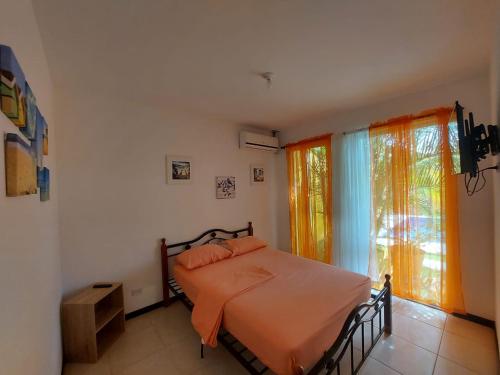 um quarto com uma cama com um cobertor laranja em Hermosa casa de playa en bejuco em Esterillos Este