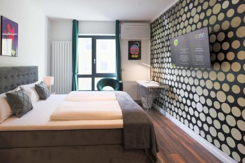 1 dormitorio con 1 cama y TV en la pared en Eco Smart Apartments Premium City en Núremberg