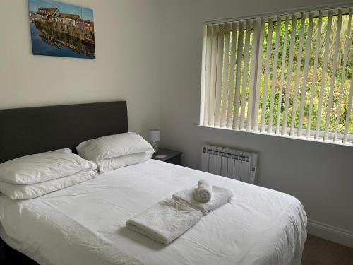 a bedroom with a white bed with towels on it at The Mandalay Guest House in Mevagissey