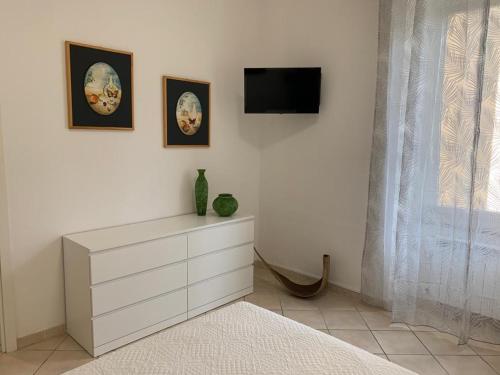 biała komoda z telewizorem na ścianie w obiekcie Ca' da Màia w mieście La Spezia