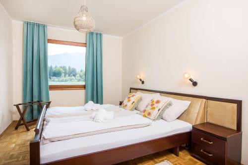 Un dormitorio con una cama grande y una ventana en Ferienhaus Faakersee Hideaway am See, en Faak am See