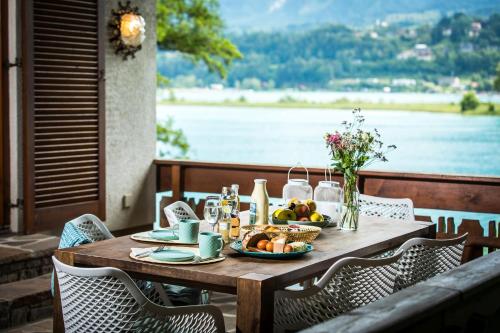 een houten tafel met een bord eten erop bij Ferienhaus Faakersee Hideaway am See in Faak am See