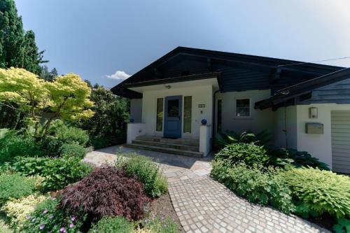 una casa con una puerta azul y algunas plantas en Ferienhaus Karawankenblick Velden, en Velden am Wörthersee