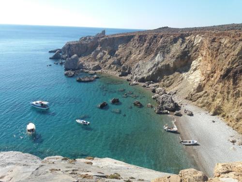 a group of boats in the water on a beach at San Georgio Hotel in Tsoútsouros