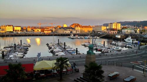 a harbor with boats in the water and a city at Le Grand Hotel in Cherbourg en Cotentin