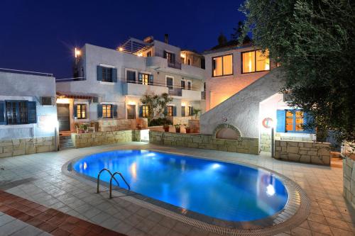 a swimming pool in front of a house at night at Stelva Villas in Hersonissos