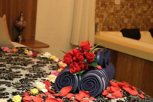 um bolo com rosas vermelhas em cima de uma mesa em Arraialferias Suites em Arraial do Cabo