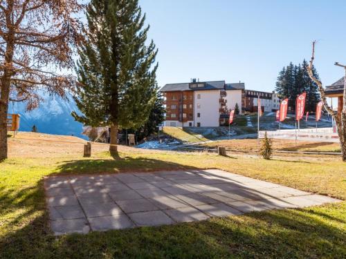 a path in a park with a tree and a building at Apartment Südlenz 41 by Interhome in Riederalp