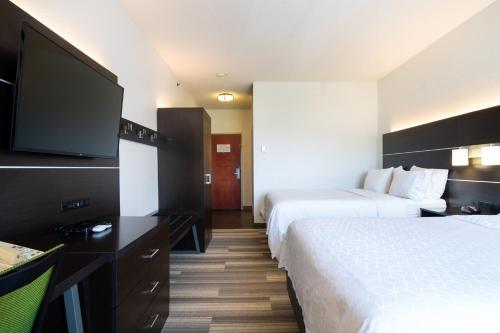 a hotel room with two beds and a flat screen tv at Holiday Inn Express Hotel & Suites Bedford by IHG in Bedford