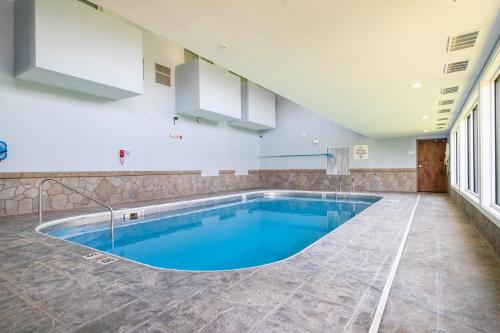 a large swimming pool with blue water in a room at Holiday Inn Express Hotel & Suites Bedford by IHG in Bedford
