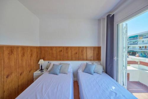1 Schlafzimmer mit 2 Betten und einem großen Fenster in der Unterkunft Nura Houses Apartment Magaluf 3 in Magaluf