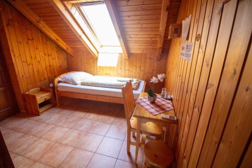 a small room with a bed in a wooden cabin at Radics Panzió Étterem és Pihenő Központ in Letenye