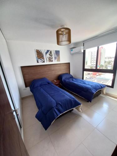 2 camas en una habitación con almohadas azules en Marqués de Tojo Urbano en San Salvador de Jujuy