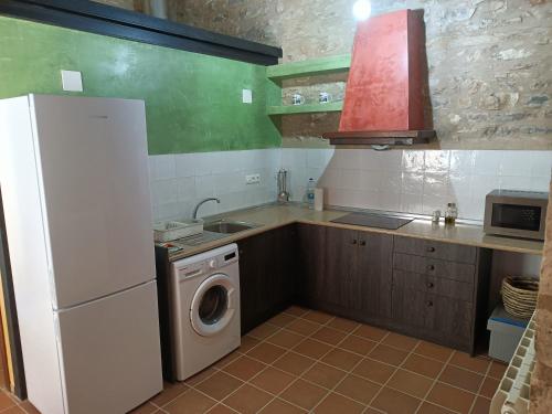 cocina con nevera y lavadora en Casa Els Arcs, en Castellfort