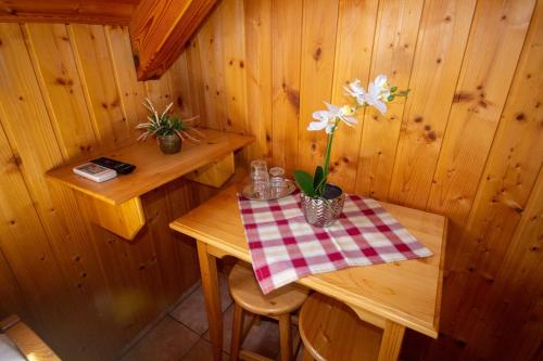 a small wooden room with a table with flowers on it at Radics Panzió Étterem és Pihenő Központ in Letenye
