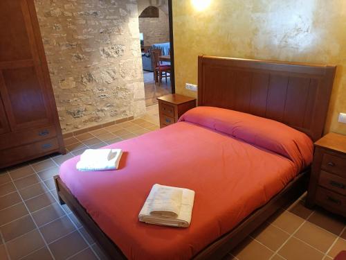 1 dormitorio con 1 cama con sábanas rojas y espejo en Casa Els Arcs, en Castellfort