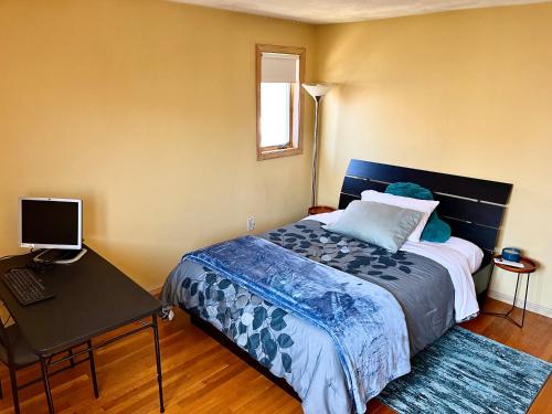 a bedroom with a bed and a desk with a computer at Inviting room with workstation in Revere
