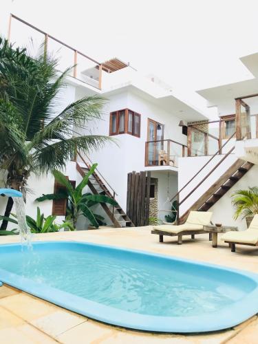 a swimming pool in front of a house at Villa Mar Residence in Jericoacoara
