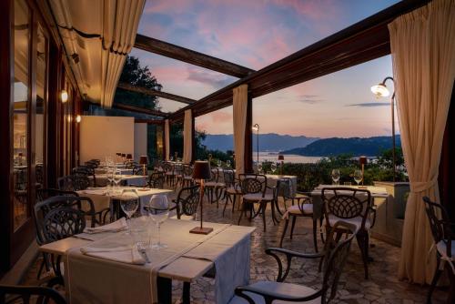 a dining room with tables and chairs and a large window at Doria Park Hotel in Lerici