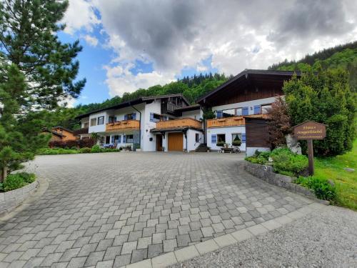 ein großes Haus mit einer Einfahrt davor in der Unterkunft Haus Angerbichl in Ramsau bei Berchtesgaden