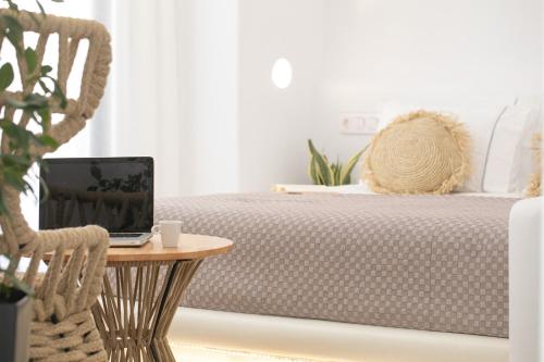 a bedroom with a bed with a laptop on a table at Majestique of Naxos in Naxos Chora