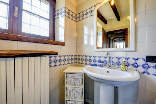 a bathroom with a sink and a mirror at Casale Lucrezia by Garda FeWo in Salò