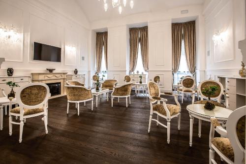 sala de estar con sillas, mesas y TV en Prestige Hotel Budapest, en Budapest