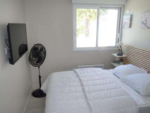 sypialnia z białym łóżkiem i oknem w obiekcie Sol-y-Days Darse, Superbe appartement de type Marina avec belle terrasse vue port de plaisance w mieście Le Grau-du-Roi
