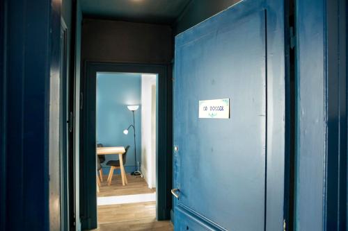 ein blauer Flur mit Tür mit Schild drauf in der Unterkunft GREEN APPART2 La Doller avec Jardin Privé in Mulhouse