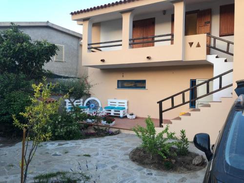 a house with a staircase in front of it at Residenze di Via Magnolie in Porto Ottiolu