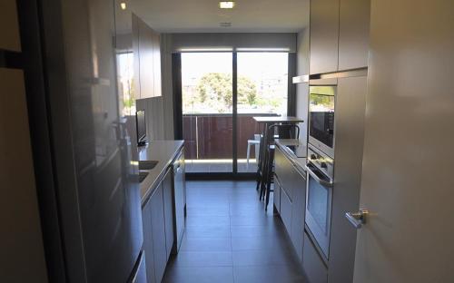una cocina con un pasillo con ventana y barra en Can Robert Sitges, en Sitges