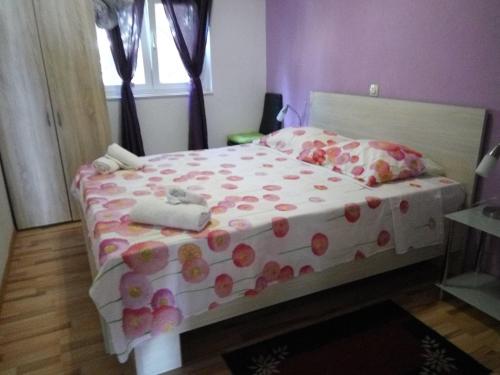 a bedroom with a bed with polka dot sheets and pillows at Apartments Jasminka in Solin