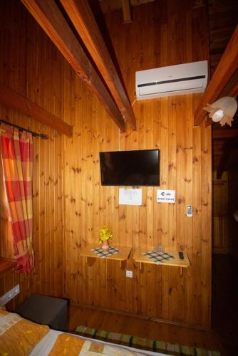 a bedroom with a wooden wall with a tv on it at Radics Panzió Étterem és Pihenő Központ in Letenye