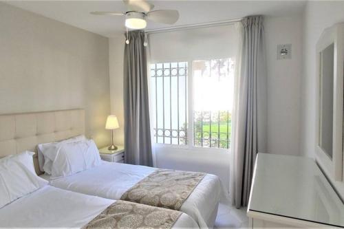 una camera bianca con un letto e una finestra di Quiet 2 bedroom apartment-Sleeps up to 6 a Mijas