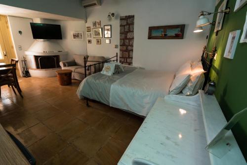 a bedroom with a bed and a living room with a fireplace at Rafalias Mansion in Hydra