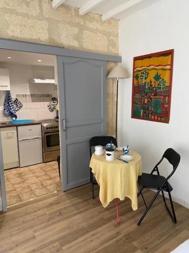 une pièce avec une table et des chaises et une cuisine dans l'établissement Charmant studio à 2 pas du centre historique, à Sommières