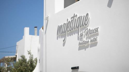 a sign on the side of a white building at Majestique of Naxos in Naxos Chora