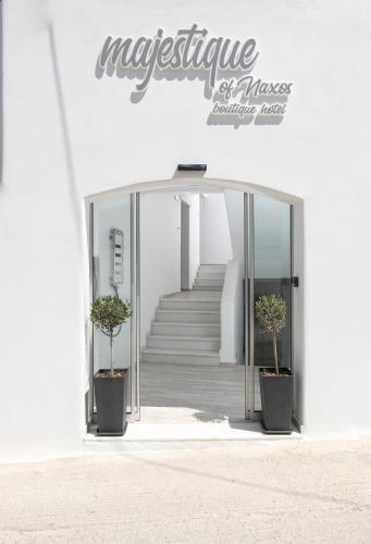 a entrance to a white building with two potted plants at Majestique of Naxos in Naxos Chora