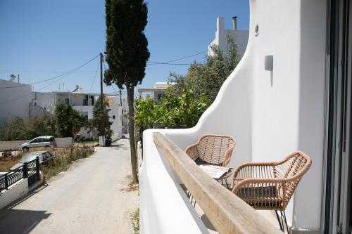 two benches sitting on a wall next to a street at Majestique of Naxos in Naxos Chora