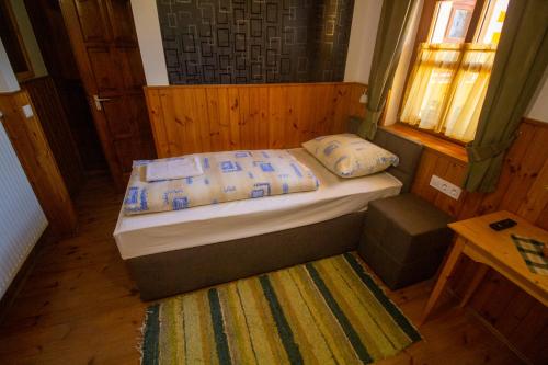 a small bedroom with a bed and a window at Radics Panzió Étterem és Pihenő Központ in Letenye