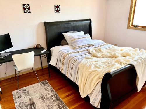 a bedroom with a bed and a desk with a computer at Cheerful, sun-kissed room with workstation in Revere