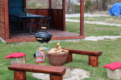 a grill next to a picnic table and a picnic bench at Dřevěný anděl in Lodhéřov