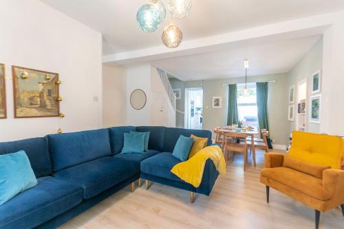 uma sala de estar com um sofá azul e duas cadeiras em Picture House em St. Ives