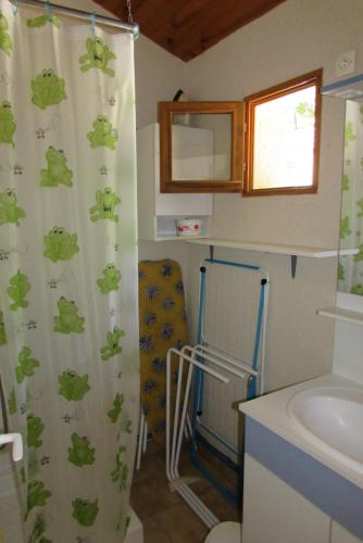 La salle de bains est pourvue d'un lavabo et d'un rideau de douche. dans l'établissement Les chalets du Verger des Ascarines, à Corneilla-de-Conflent