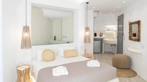 a white bedroom with a bed and a bathroom at Majestique of Naxos in Naxos Chora
