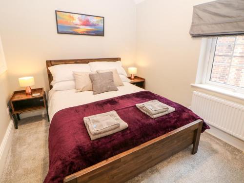 a bedroom with a large bed with two towels on it at Middle Cottage in Ashbourne