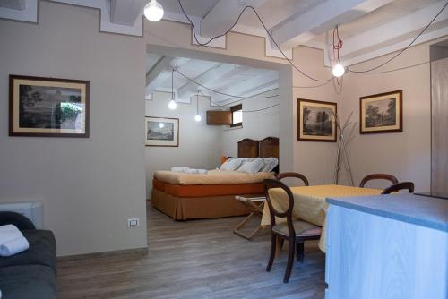 a room with two beds and a table and chairs at Relais Borgo Campello in Campello sul Clitunno